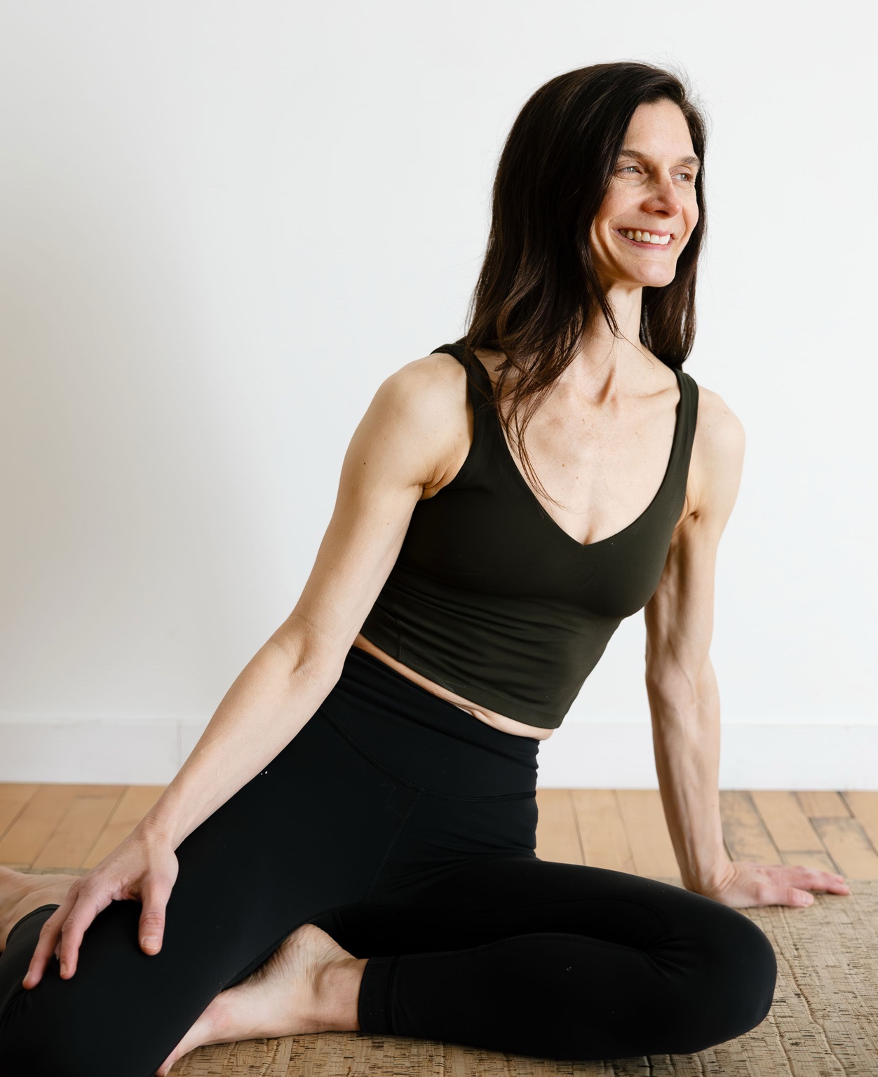 Alisa Willman seated on a cork floor, smiling and at ease